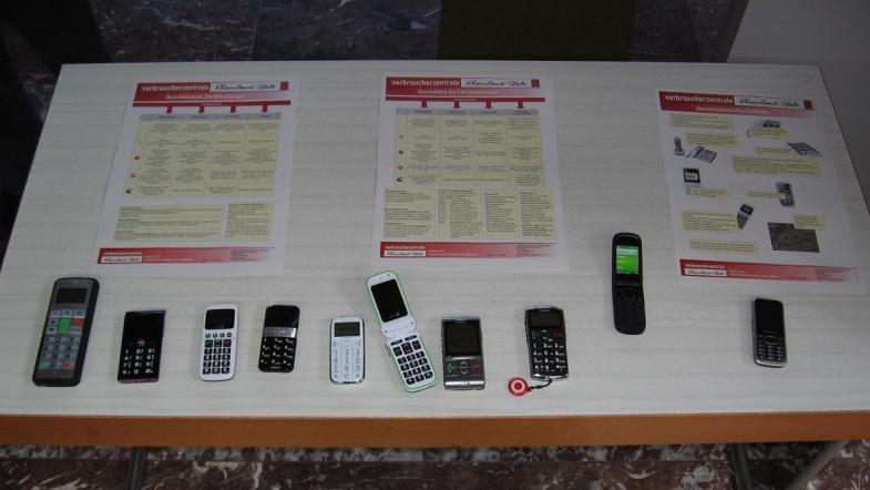 Auf einem Tisch liegen verschiedene Telefone und Handys.