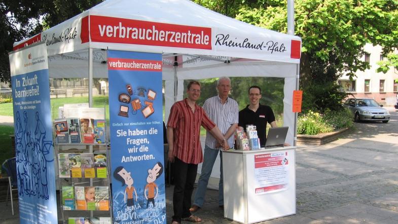Ein Straßenstand mit Zelt und Personen davor. 