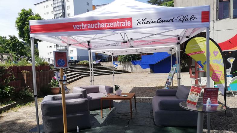 Zwei Sofas auf einem Platz unter einem Messezelt.