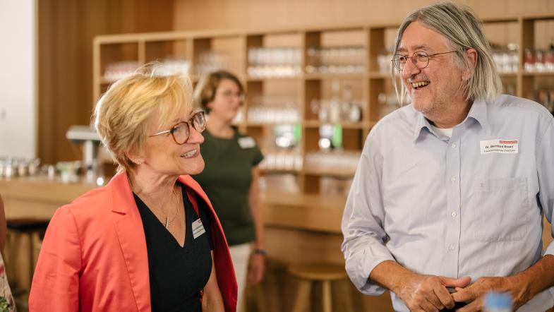 Zwei Menschen vor einer Bar im Gespräch.