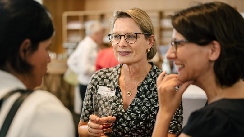 Drei Frauen vor einer Bar im Gespräch