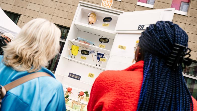 Zwei Frauen von hinten vor einem sehr großem Kühlschrank