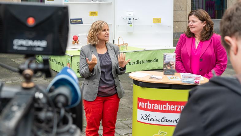 Eine Frau hält vor einer Fernsehkamera eine Rede.