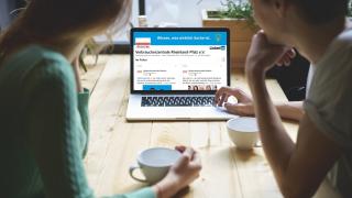 zwei Frauen sitzen vor einem PC auf dem LinkedIn geöffnet ist.