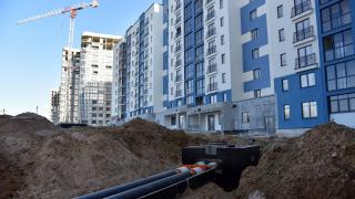 Fernwärmeleitungen die zu Rohbauten von Mehrfamilienhäusern führen. 