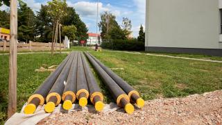 Heizungsrohre liegen vor einem Haus und müssen verlegtwerden.