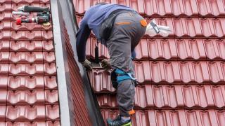 Ein Handwerker repariert ein Dach.