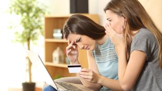 Frauen am Laptop sitzend schauen schockiert aufs Display