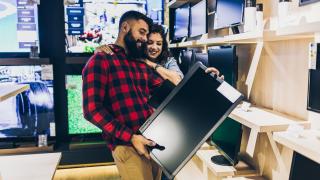 Paar sucht im geschäft nach einem Fernseher