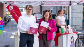 Zwei Personen bei der Übergabe eines Förderbescheids