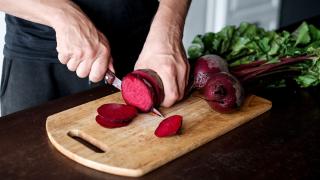 Frau schneidet rote Beete