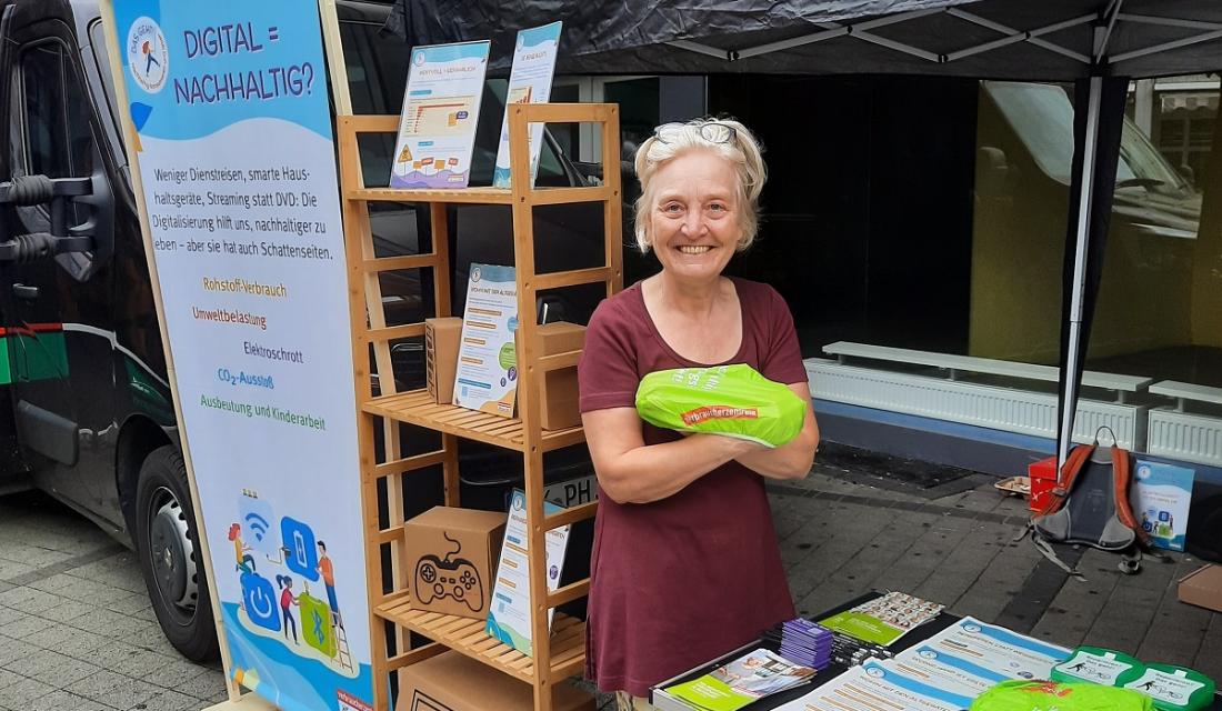 Frau vor einem Wochenmarktstand, die in die Kamera lächelt.