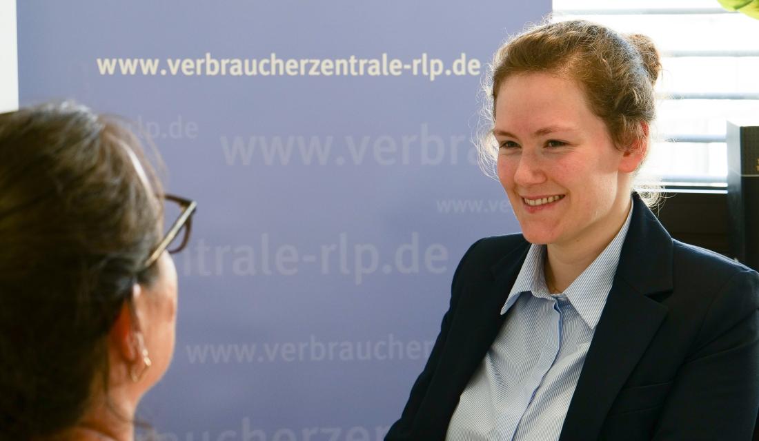 Eine Frau berät eine andere Frau an einem Tisch.